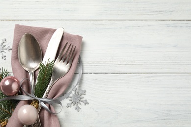 Photo of Cutlery set and festive decor on white wooden table, flat lay with space for text. Christmas celebration