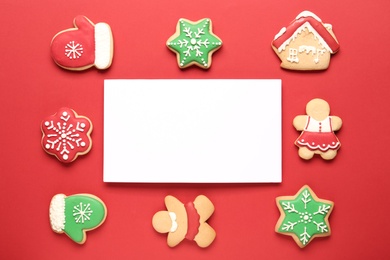 Photo of Flat lay composition with tasty homemade Christmas cookies and blank card on red background. Space for text