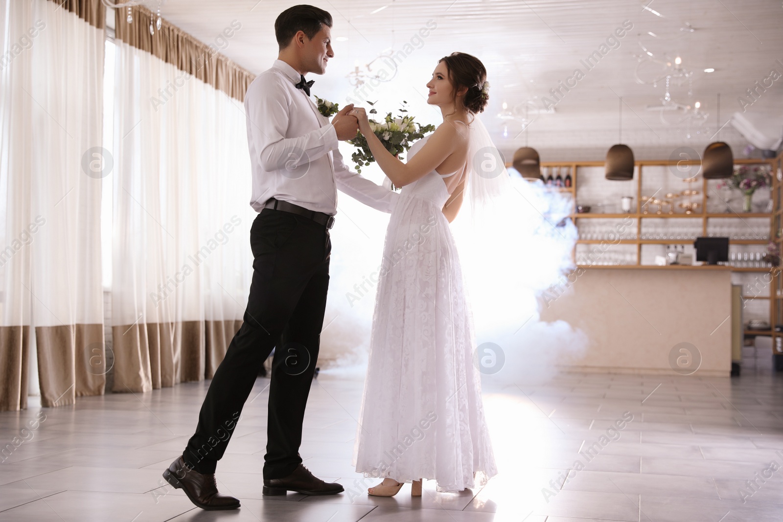 Photo of Happy newlywed couple dancing together in festive hall