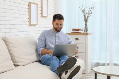 Photo of Man using laptop for online shopping at home