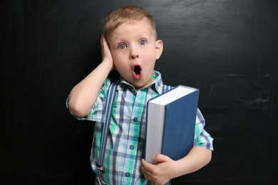 Photo of Cute little child near chalkboard. First time at school