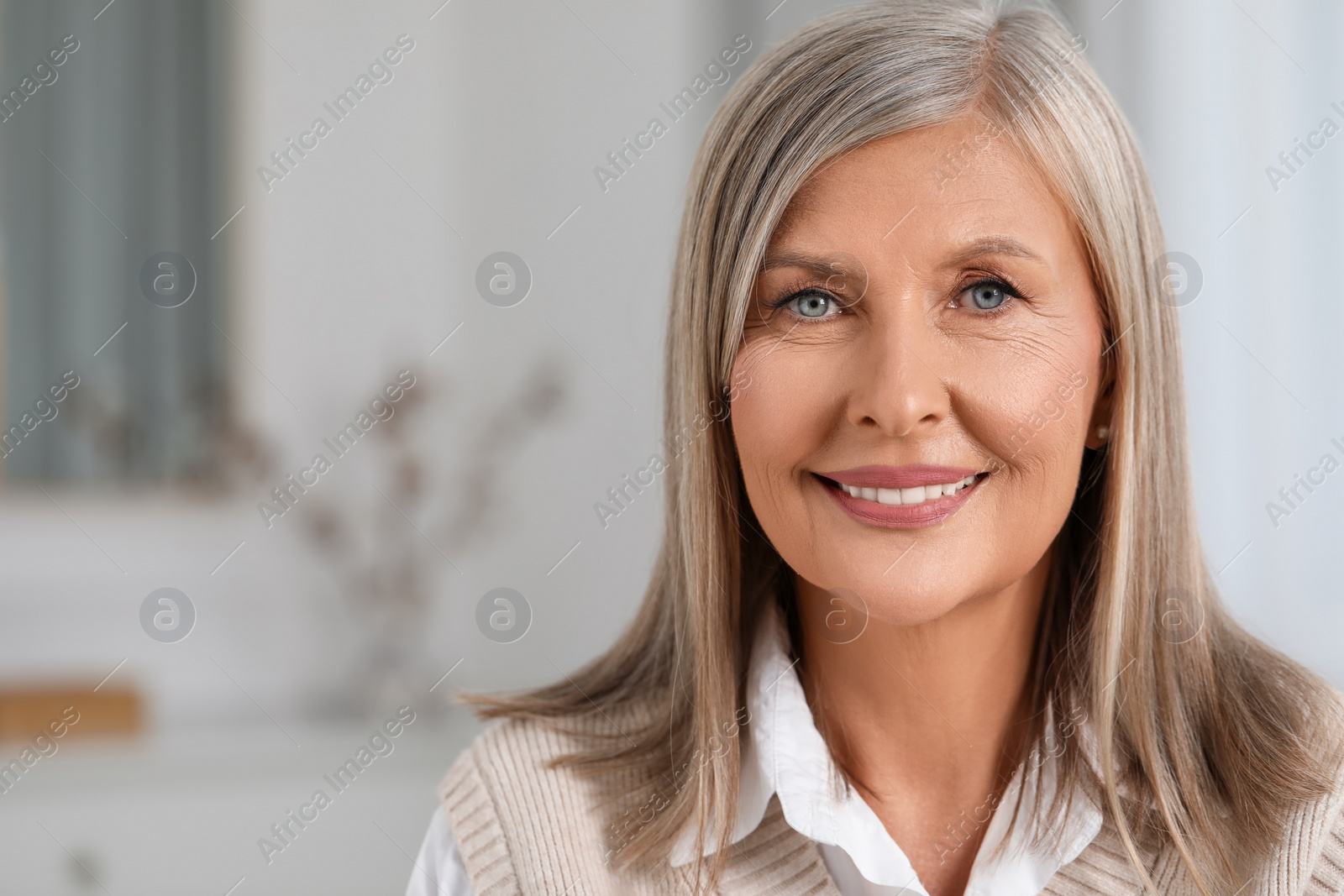Photo of Portrait of beautiful middle aged woman at home. Space for text