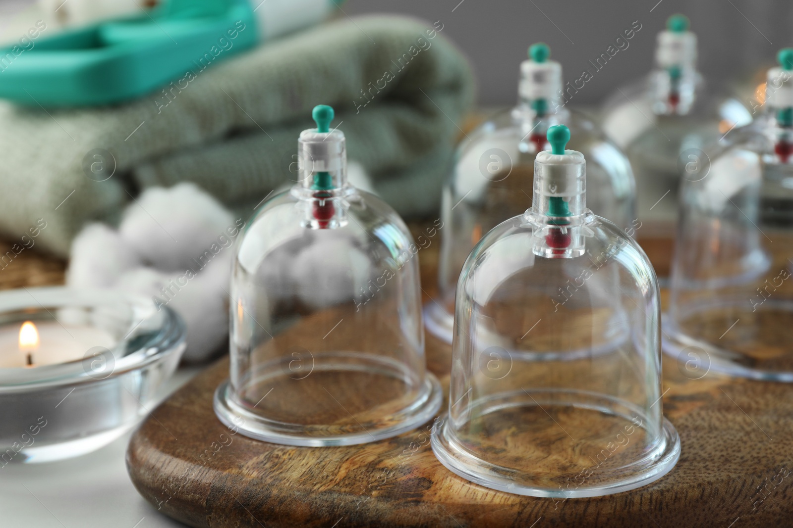 Photo of Many plastic cups on white table, closeup. Cupping therapy