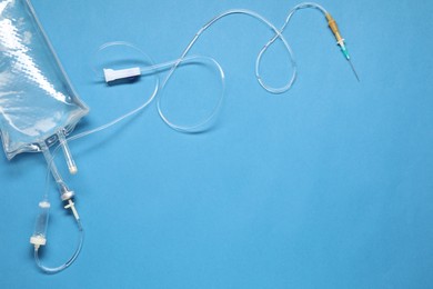 IV infusion set on light blue background, top view. Space for text