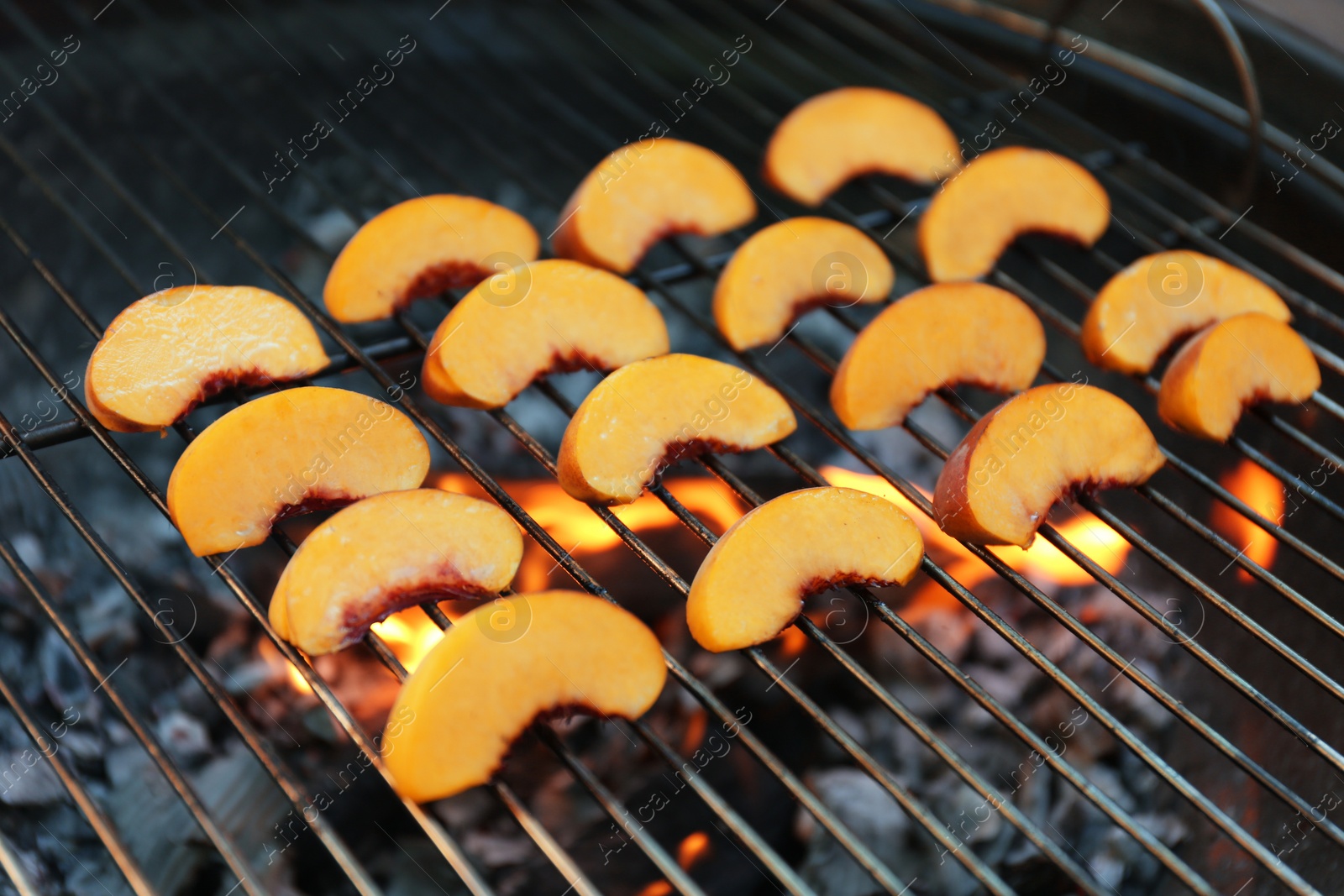 Photo of Modern grill with tasty peach slices, closeup