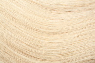 Texture of healthy blond hair as background, closeup