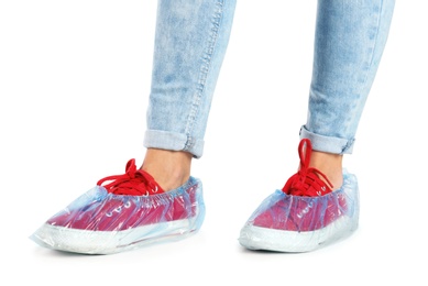 Photo of Woman with blue shoe covers worn over sneakers on white background, closeup