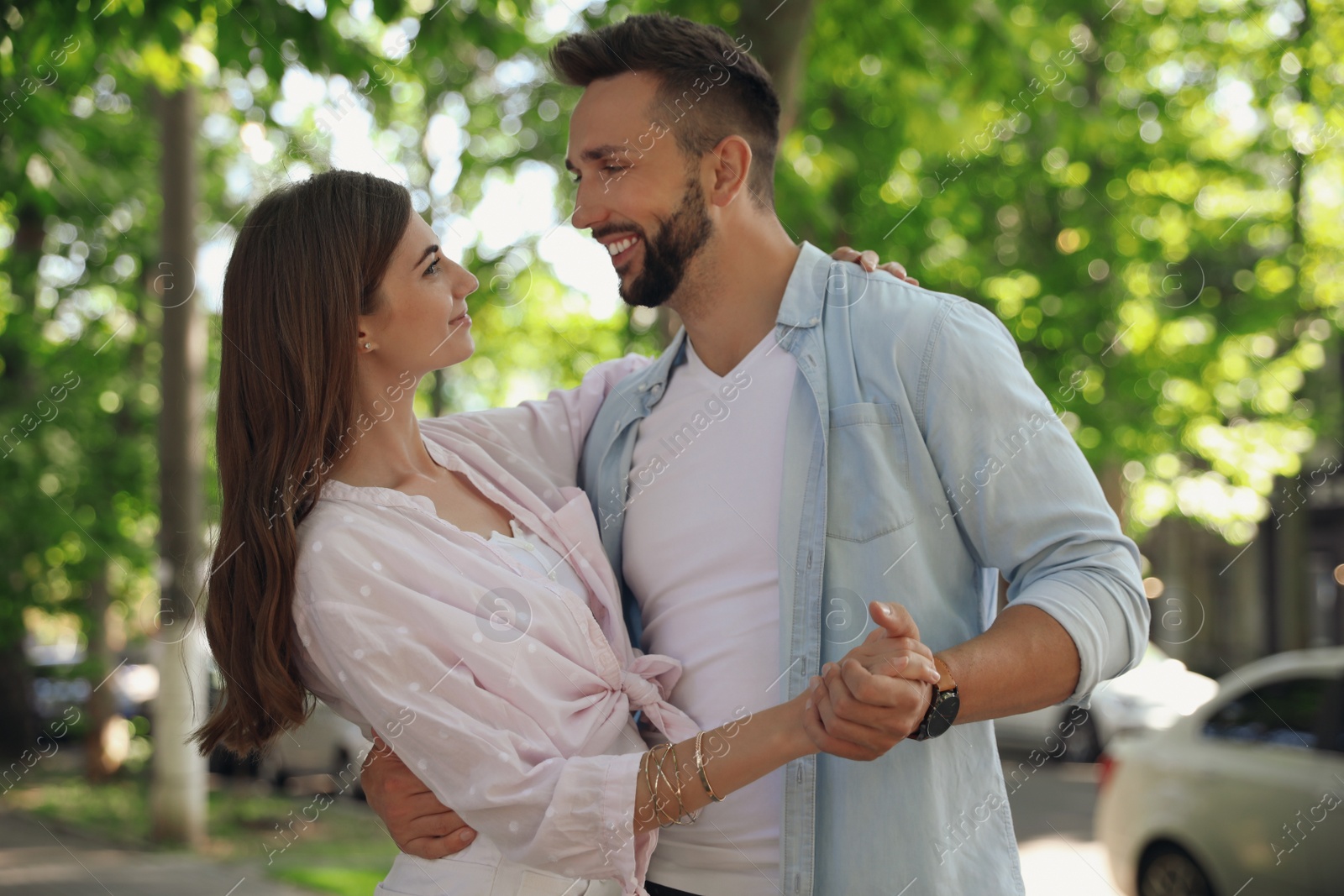 Photo of Lovely young couple dancing together outdoors on sunny day