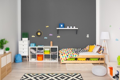 Photo of Modern room interior with comfortable bed for child