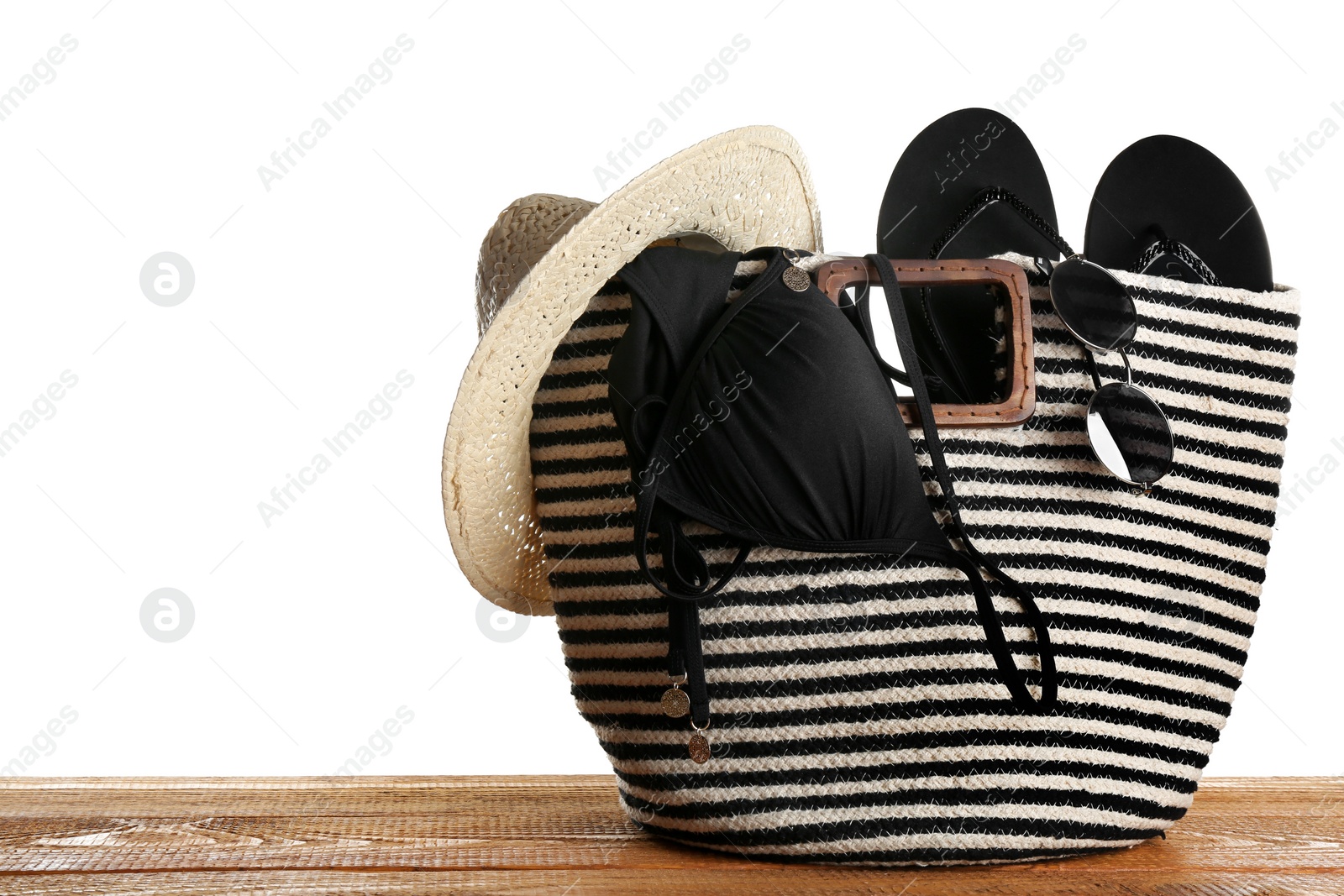 Photo of Set of beach accessories on wooden table, white background