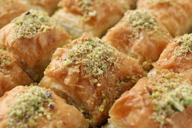 Photo of Delicious fresh baklava with chopped nuts as background, closeup. Eastern sweets