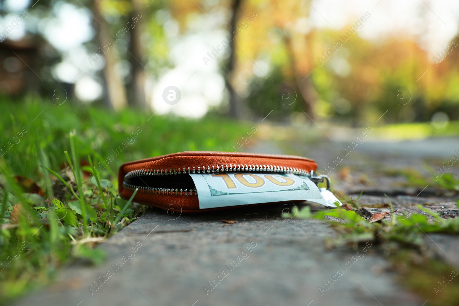 Photo of Brown leather purse on pavement outdoors. Lost and found