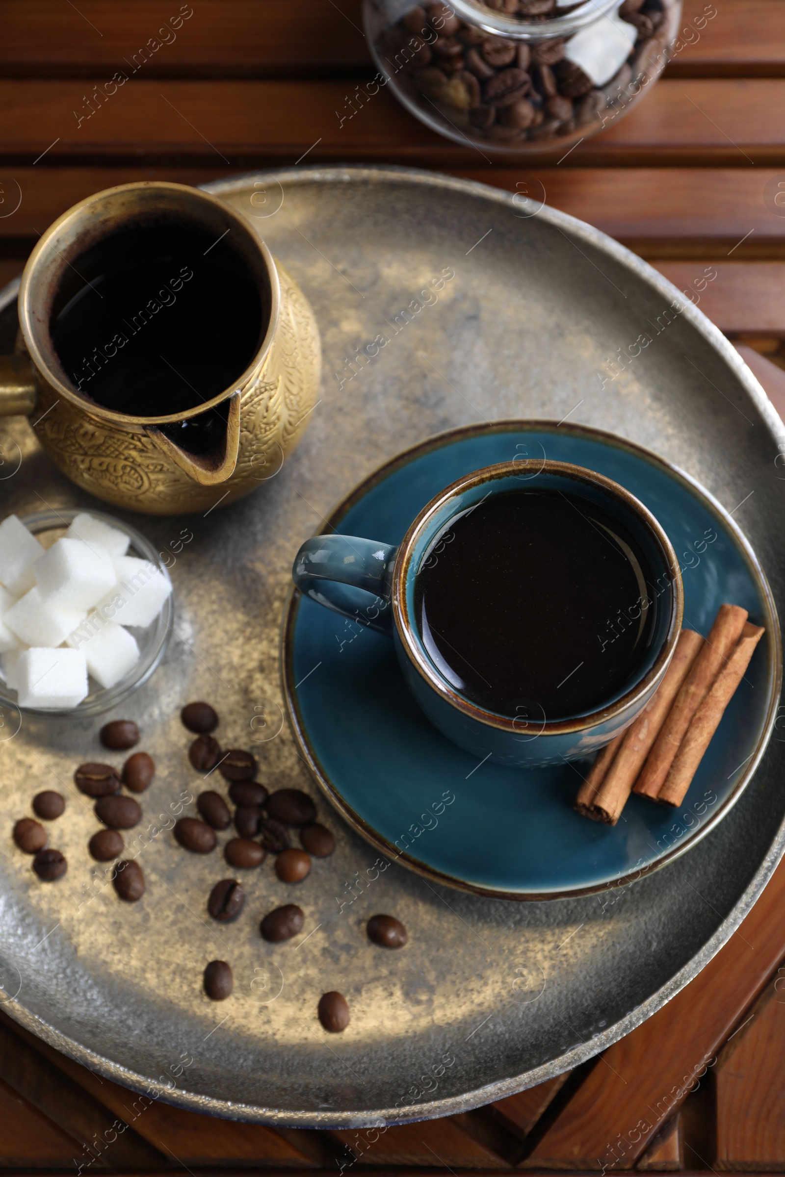 Photo of Turkish coffee. Freshly brewed beverage on wooden table, flat lay