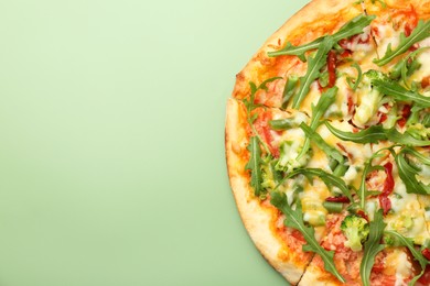 Photo of Delicious vegetarian pizza on green table, top view. Space for text