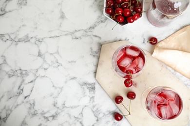 Photo of Delicious cherry wine with ripe juicy berries on white marble table, flat lay. Space for text