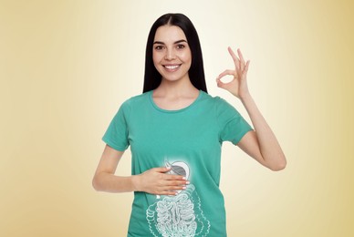 Image of Happy woman with healthy digestive system on light yellow background. Illustration of gastrointestinal tract