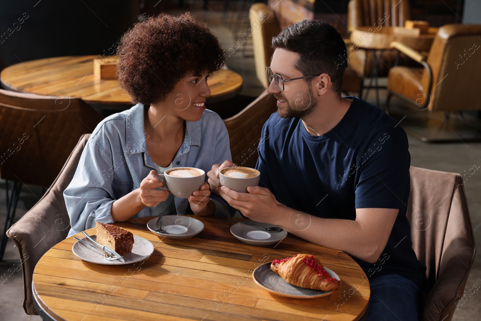 Photo of International dating. Lovely couple spending time together in cafe