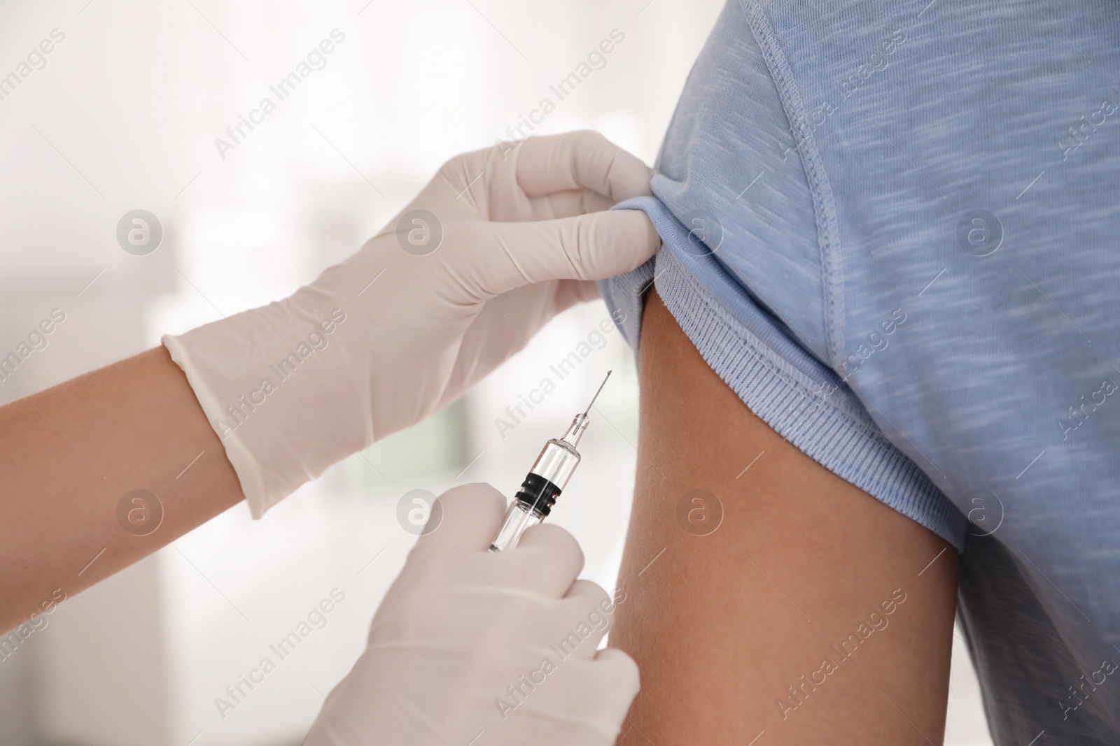 Photo of Doctor vaccinating man against Covid-19 in clinic, closeup