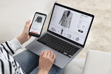 Woman with smartphone and laptop shopping online indoors, closeup