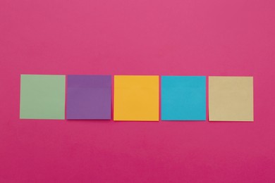 Photo of Colorful sticky notes on pink background, flat lay