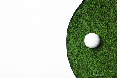 Photo of Golf ball and white paper on green artificial grass, top view with space for text