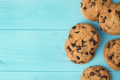 Photo of Tasty chocolate chip cookies on wooden background, top view. Space for text