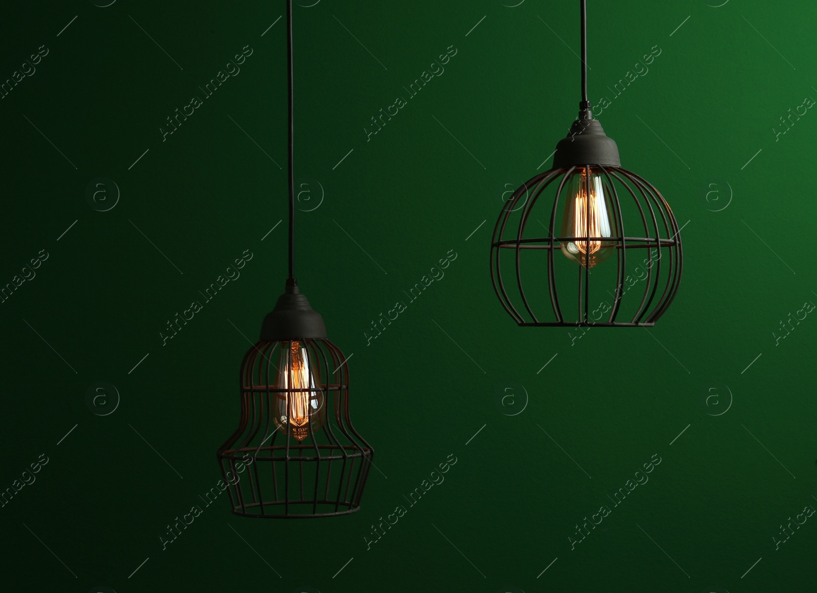 Photo of Hanging lamp bulbs in chandeliers against green background