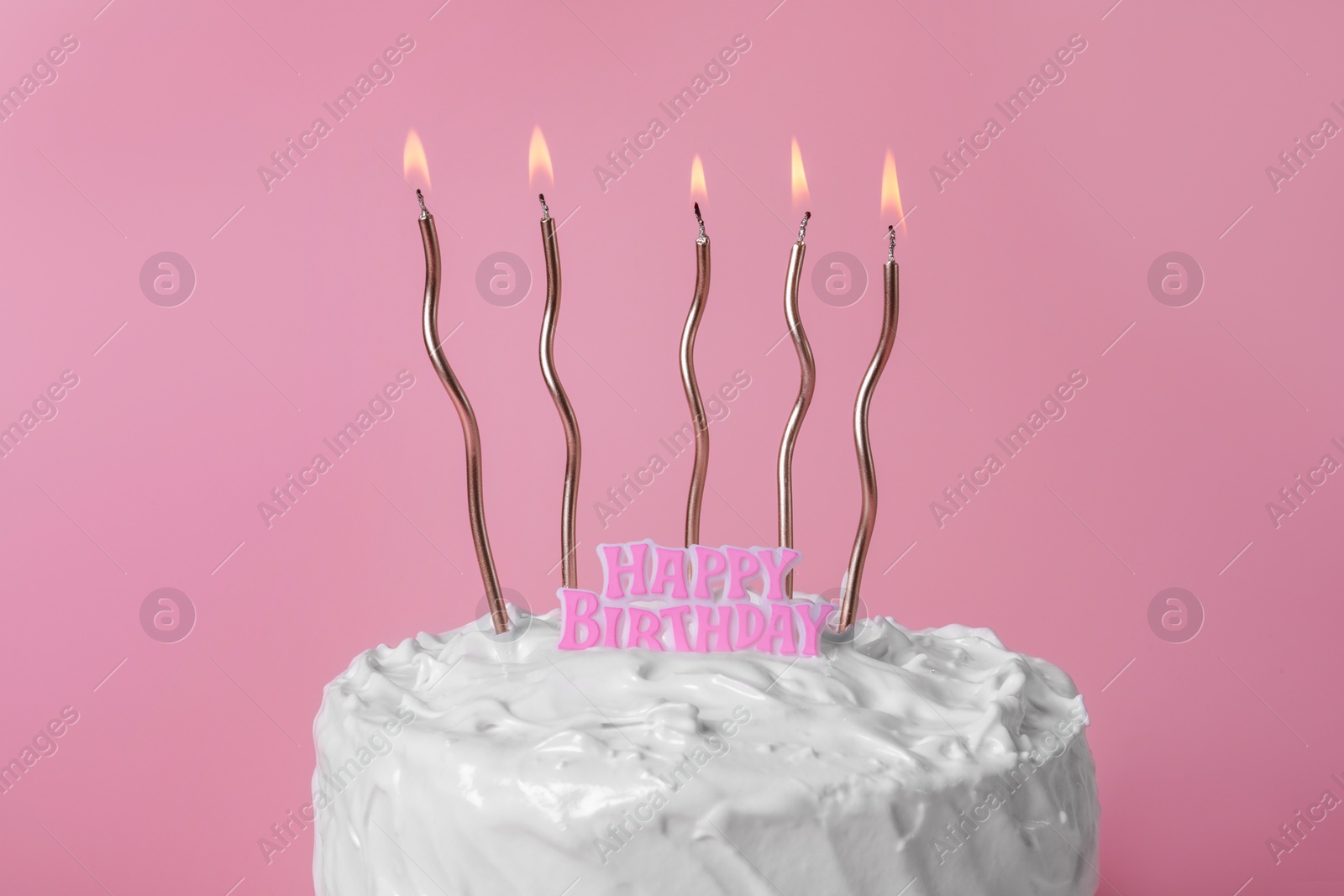 Photo of Delicious cake with cream and burning candles on pink background, closeup