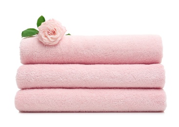 Photo of Stack of clean folded towels with flower on white background