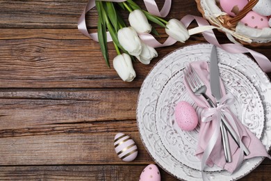 Photo of Festive table setting with painted eggs and tulips, flat lay with space for text. Easter celebration