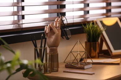 Stylish workplace with different accessories on table at window. Ideas for interior design