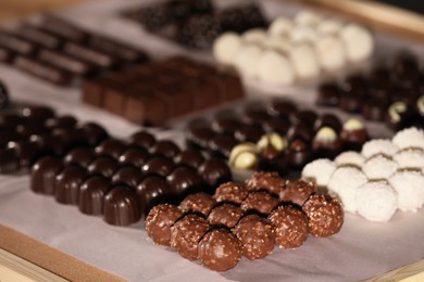 Photo of Many delicious chocolate candies on table, closeup. Production line