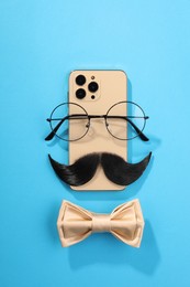Photo of Flat lay composition with artificial moustache and glasses on light blue background