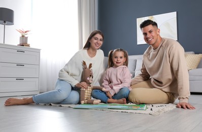 Photo of Happy family with little daughter spending time together at home. Floor heating concept