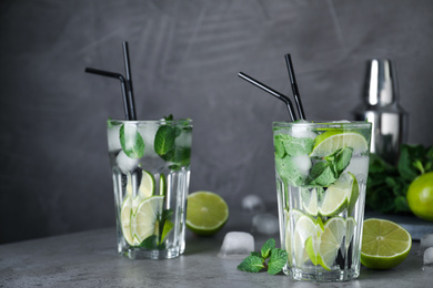 Glasses of fresh Mojito cocktail on grey table