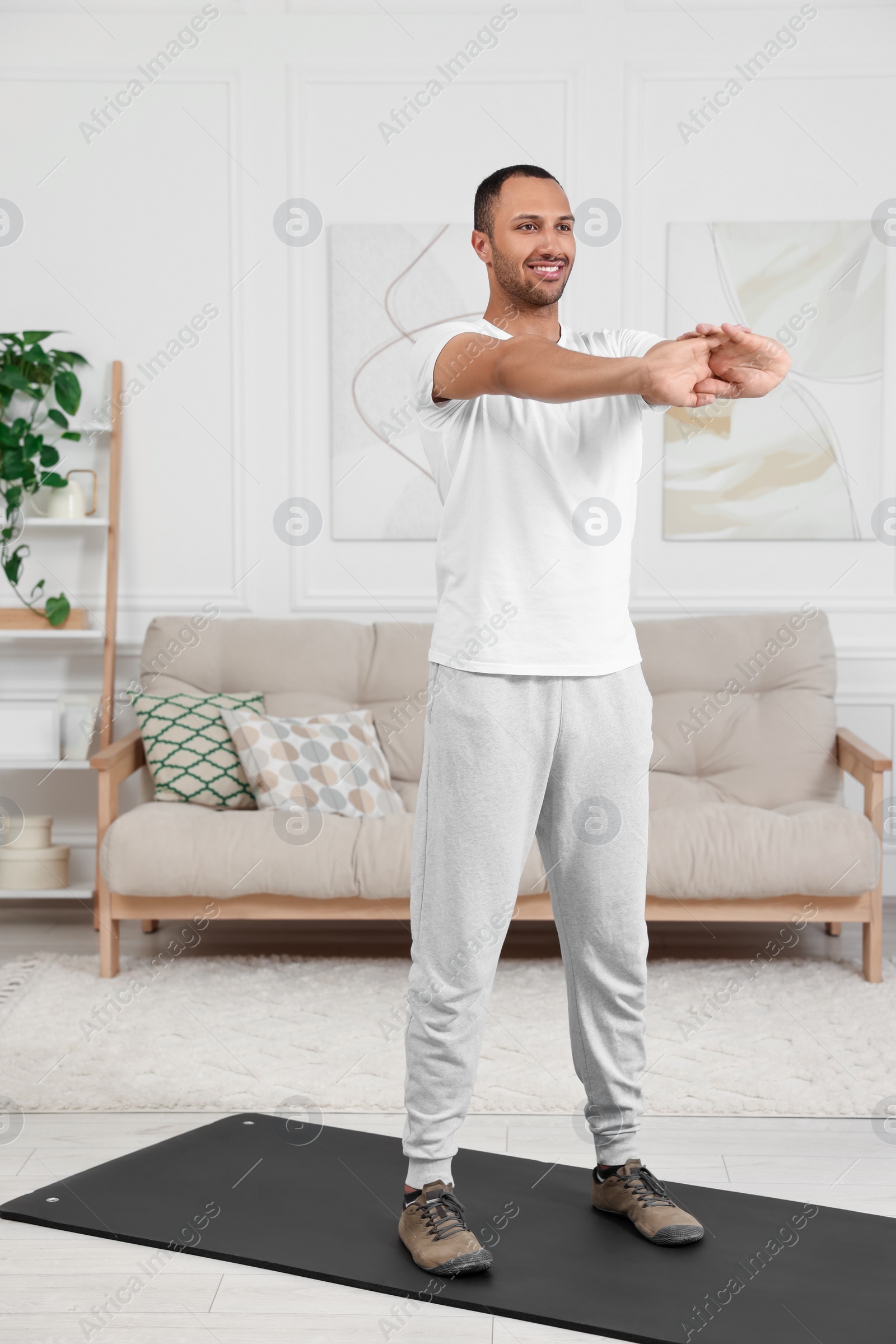 Photo of Man doing morning exercise on fitness mat at home