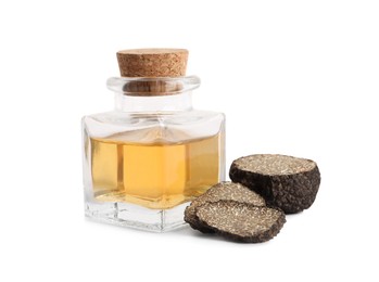 Photo of Glass bottle of oil and fresh truffles on white background