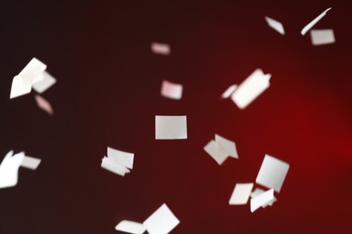 Photo of White confetti falling down, toned in red