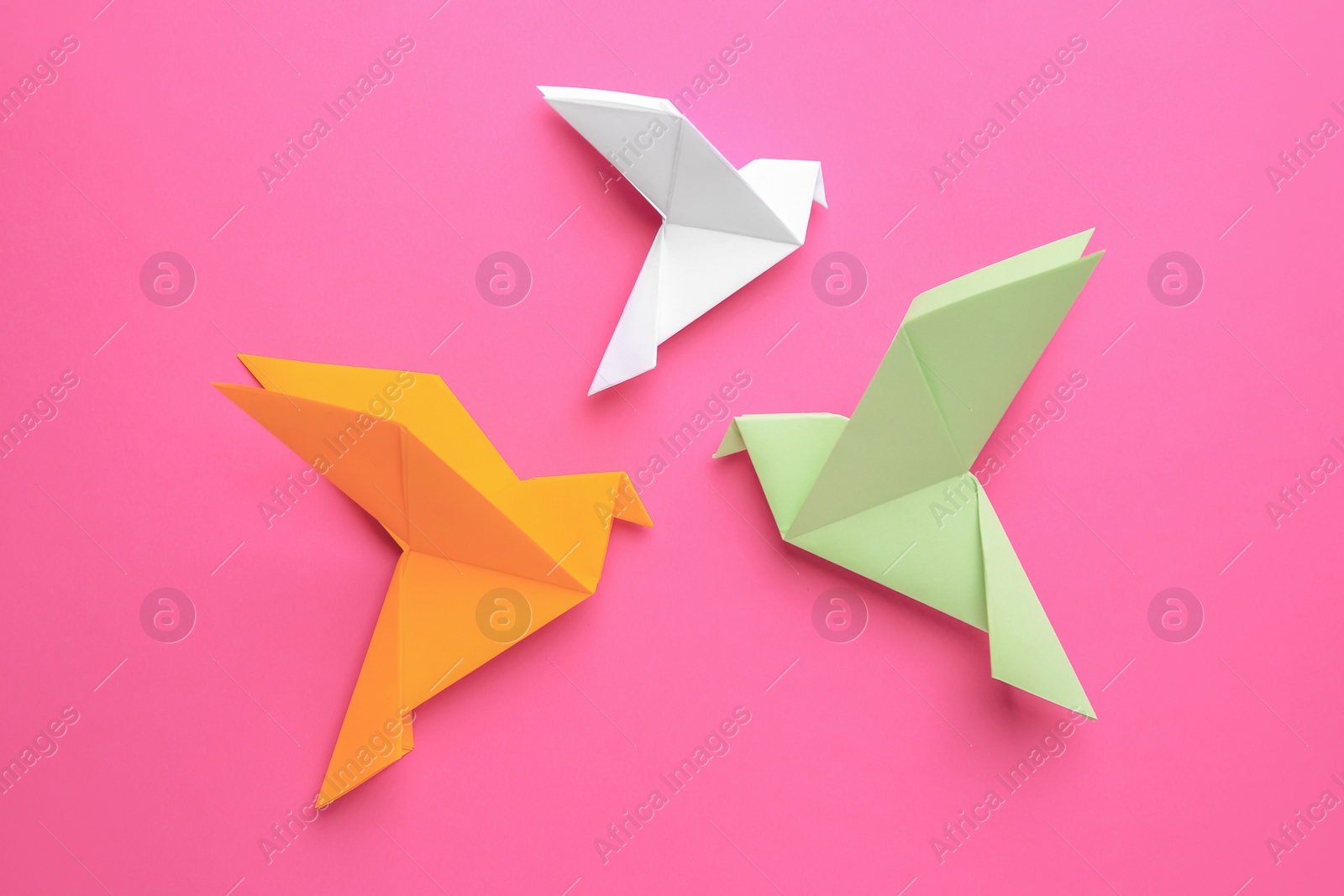 Photo of Beautiful colorful origami birds on pink background, flat lay