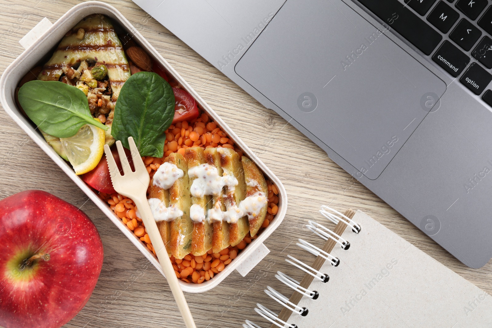 Photo of Healthy products high in vegetable fats near laptop on wooden table, flat lay