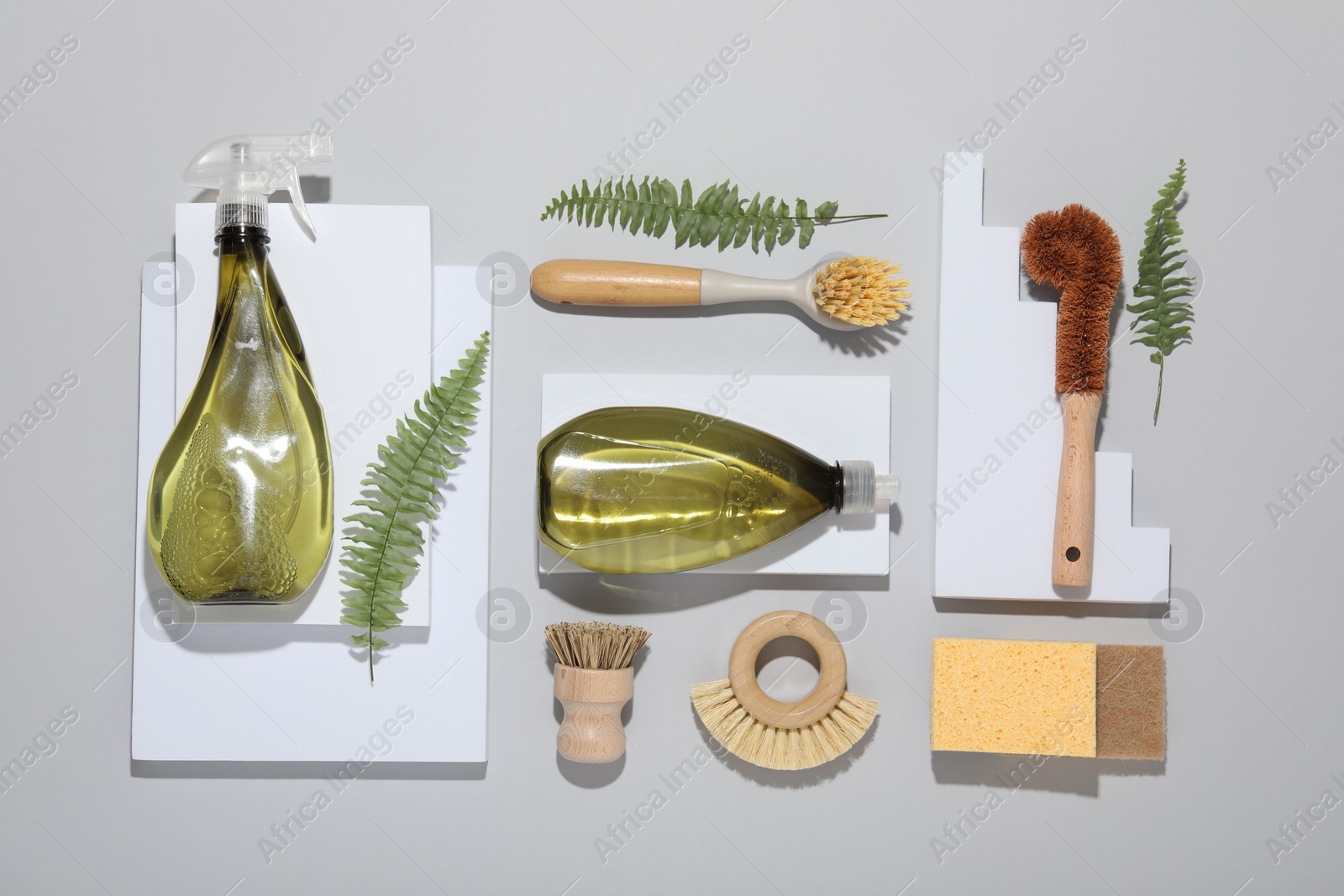 Photo of Flat lay composition with different cleaning supplies on light gray background