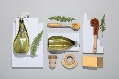 Flat lay composition with different cleaning supplies on light gray background