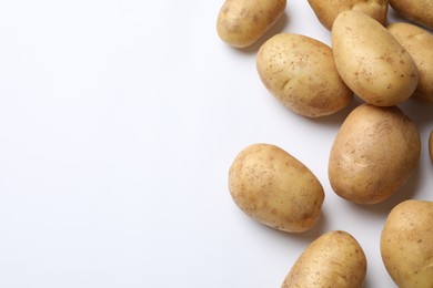 Photo of Fresh raw potatoes on white background, flat lay. Space for text