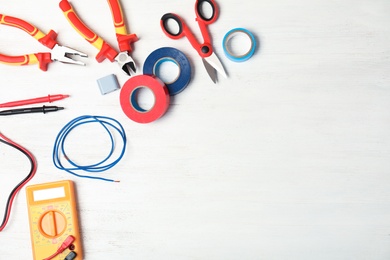 Photo of Flat lay composition with electrician's tools and space for text on wooden background