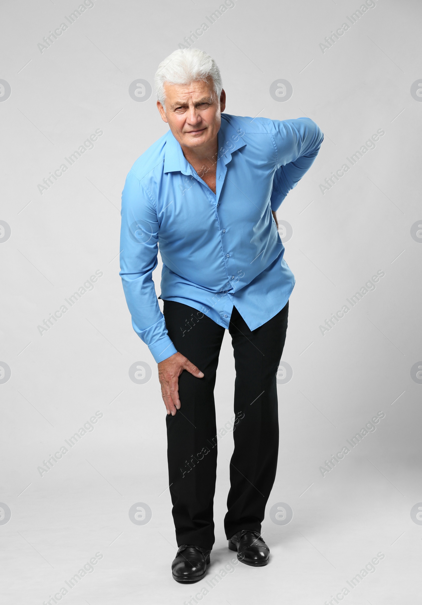 Photo of Full length portrait of senior man having knee problems on grey background