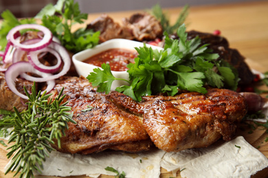 Photo of Delicious roasted chicken tobacco with herbal on wooden board, closeup