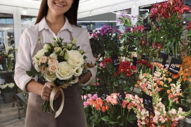 Florist holding beautiful wedding bouquet in flower shop, closeup