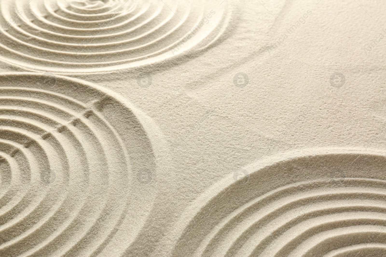 Photo of Beautiful patterns on sand, closeup. Zen garden