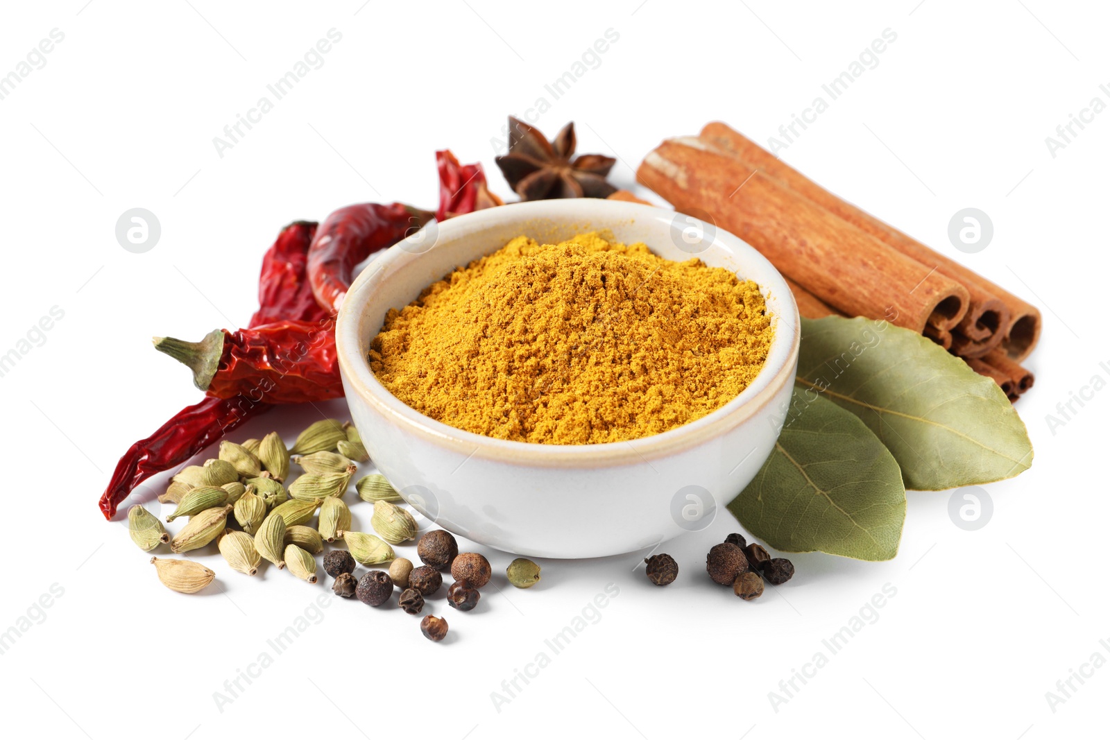 Photo of Curry powder in bowl and other spices isolated on white