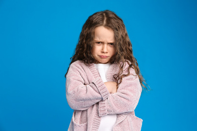 Photo of Portrait of cute little girl on light blue background